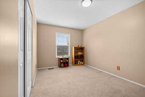 Bedroom featuring light colored carpet and a closet