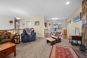 Living area featuring light colored carpet and a textured ceiling