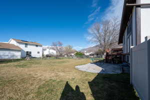 Fenced backyard featuring a deck with mountain view and a patio