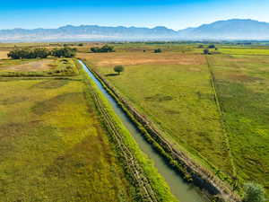 Overview of rural landscape featuring a pastoral area and a water and mountain view