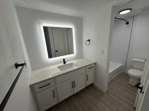 Full bathroom featuring vanity, dark wood-style flooring, and bathtub / shower combination