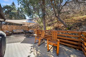 Wooden deck featuring grilling area and an outdoor living / dining area