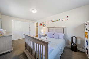 Bedroom featuring dark carpet and a closet