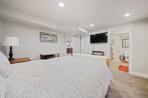 Bedroom featuring light carpet, recessed lighting, and ensuite bathroom