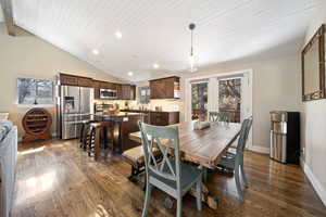 Dining space featuring dark wood-style floors, recessed lighting, and vaulted ceiling