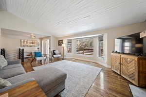 Living room with dark wood-style floors and a vaulted wooden ceiling