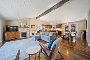 Living area with dark wood finished floors, a fireplace, and beam ceiling