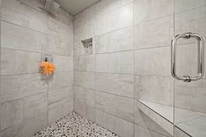 Full bath featuring a tile shower