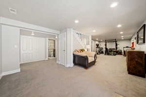 Living area featuring light carpet and recessed lighting