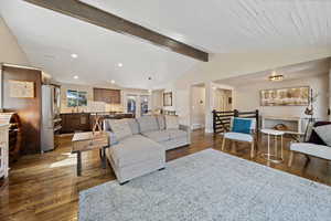 Living room featuring dark wood-type flooring, beamed ceiling, and recessed lighting