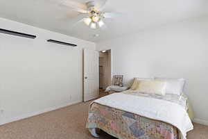 Bedroom with light carpet, a textured ceiling, and ceiling fan