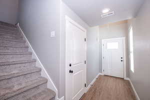 Doorway to outside featuring baseboards and wood finished floors