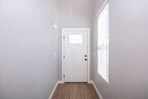 Doorway to outside with baseboards and wood finished floors