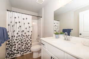 Bathroom with vanity, dark wood-type flooring, and shower / bath combo