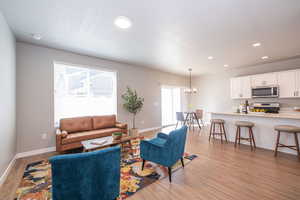 Living room featuring light wood-style floors and a chandelier