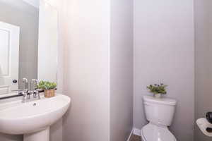 Half bathroom featuring toilet and baseboards