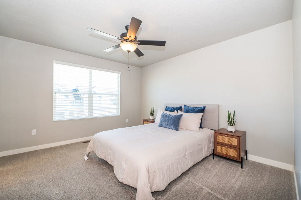 Carpeted bedroom featuring baseboards and a ceiling fan