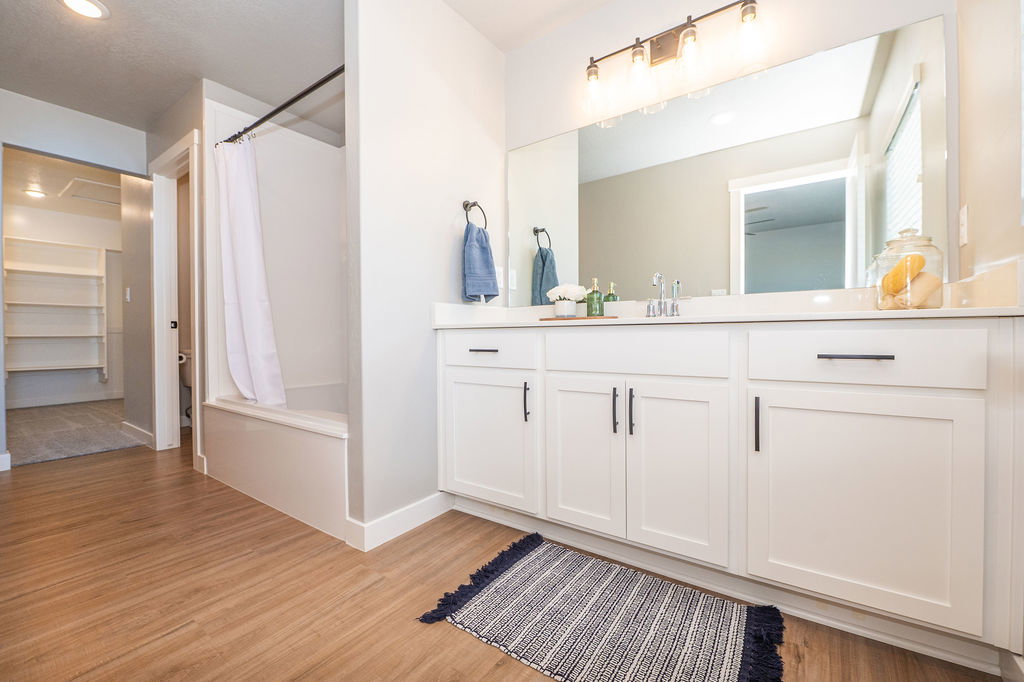 Full bathroom featuring vanity, shower / bath combo, and light wood-style flooring