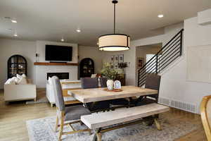 Dining room with a fireplace, light wood finished floors, and recessed lighting