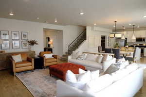 Living room with light wood-type flooring and recessed lighting