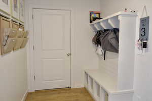Mudroom featuring light wood-type flooring and baseboards