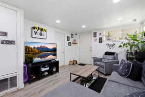 Basement living area with light wood-type flooring and recessed lighting