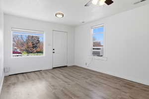 Living room with light wood finished floors, a ceiling fan, and cooling unit