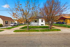 View of front of house featuring a residential view, a porch, a front lawn, and driveway