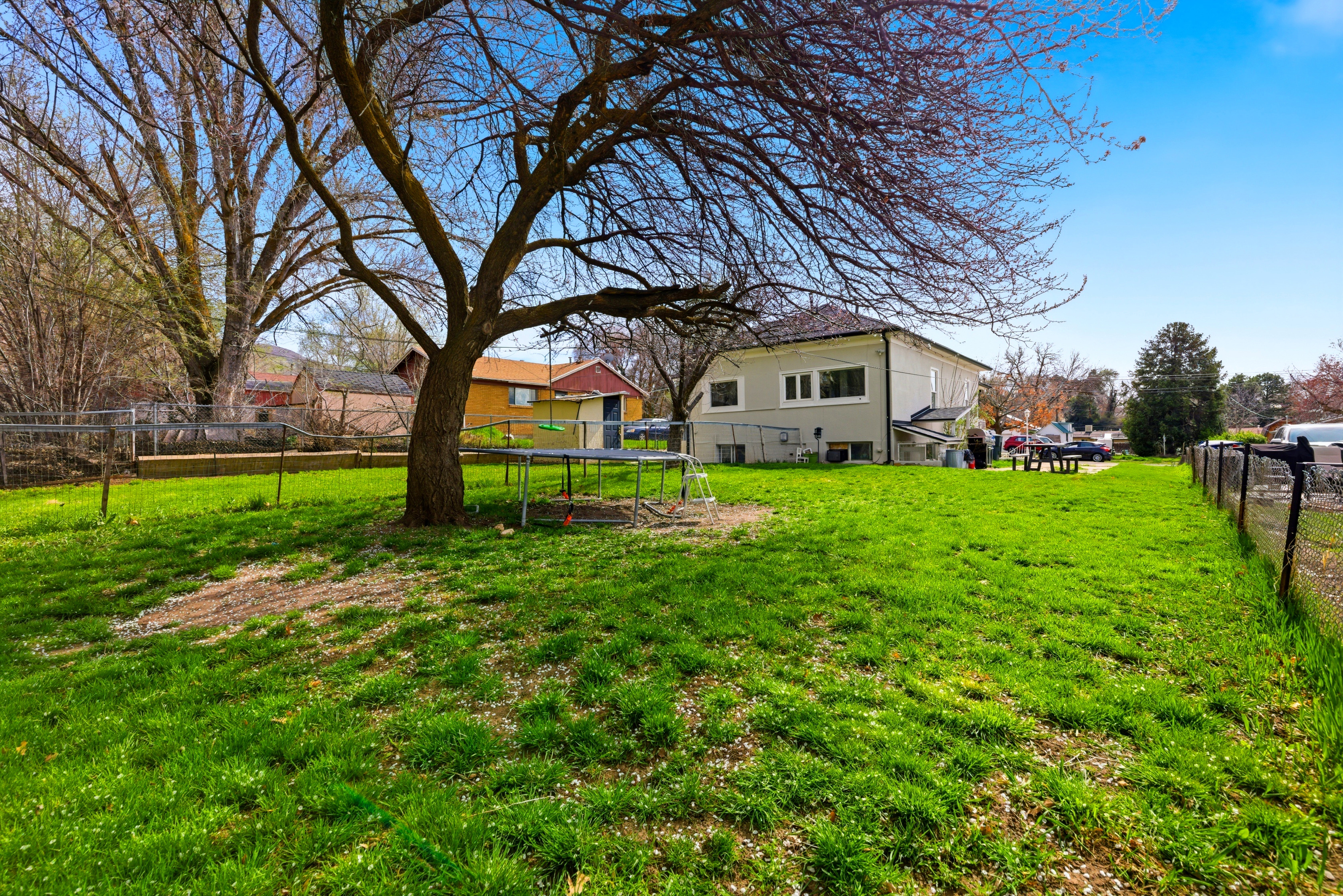 Fenced backyard with a trampoline