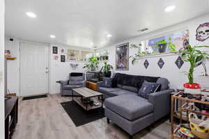 Basement living room featuring light wood-style flooring and recessed lighting