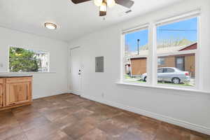 Unfurnished dining area with a ceiling fan and electric panel