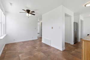 Spare room with a ceiling fan and baseboards