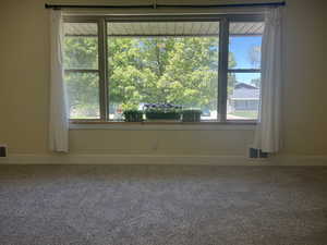 Carpeted spare room with baseboards