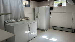 Laundry area featuring concrete flooring and washing machine and dryer