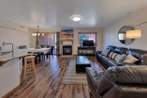 Living room featuring a tile fireplace, dark wood-type flooring, and suspended lighting
