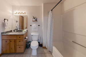Bathroom with vanity, light tile patterned floors, and shower / bath combo with shower curtain
