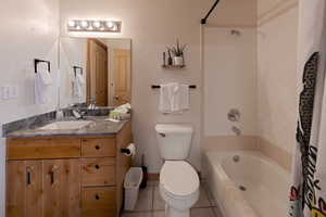 Bathroom featuring vanity, shower / tub combo with curtain, and light tile patterned flooring