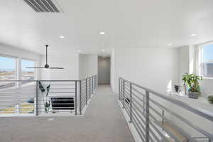 Corridor with light carpet, recessed lighting, and an upstairs landing