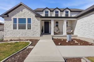 Property entrance featuring a porch and stone siding