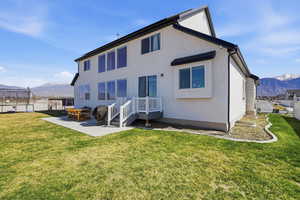 Back of house featuring a mountain view, a patio area, and stucco siding