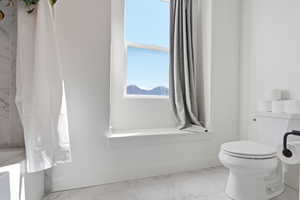 Bathroom with toilet and light marble finish floors