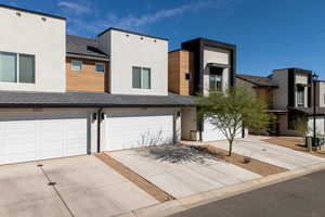 Contemporary house with driveway, stucco siding, and a garage