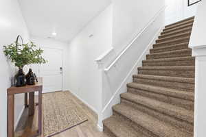 Entrance foyer featuring stairway and light wood-style floors