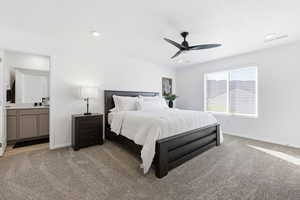 Primary Bedroom with light colored carpet, a ceiling fan, and connected bathroom