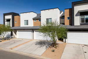 Modern home with driveway, a garage, and stucco siding