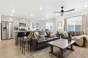 Living room featuring healthy amount of natural light, light wood-type flooring, recessed lighting, and a ceiling fan