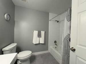 Hallway Bathroom with vanity, dark tile patterned floors, with  shower / bath combo