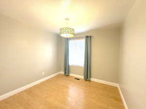 Bedroom (2) Laminate light wood-style floor with chandelier light and double door closet