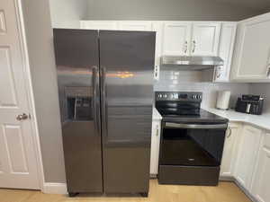 White cabinets, quartz countertop, and backsplash