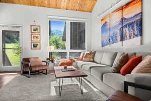 Living room with a vaulted wooden ceiling and wood finished floors